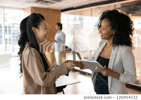 Two businesswomen handshaking as gesture of successful business meeting outcome 126954532