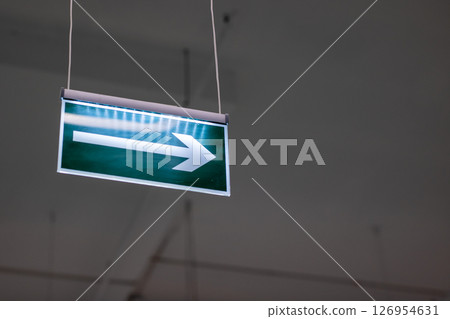 A bright green exit sign is displayed with an arrow pointing to the right 126954631