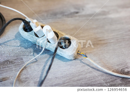 A collection of various electrical wires is connected to a power strip 126954656