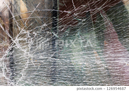 This is a close up view featuring a broken glass window 126954687