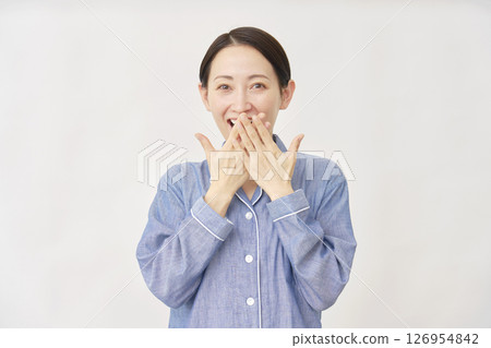 Smiling and surprised woman in pajamas on white background Smiling and surprised woman in pajamas on white background 126954842