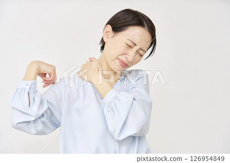 Woman in her 40s with stiff shoulders, white background Woman in her 40s with stiff shoulders, white background 126954849