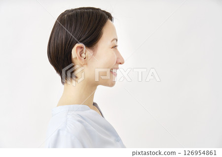 40 多歲女性使用助聽器，白色背景 126954861