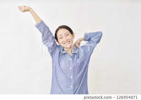 Woman in pajamas stretching on white background 126954871