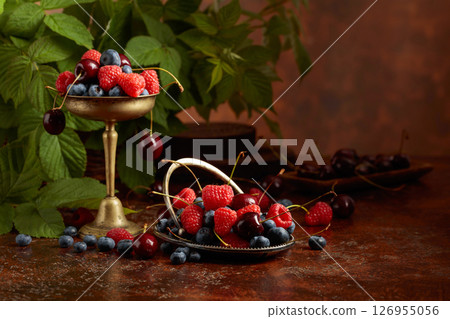 Berries with leaves on an old brown table. 126955056