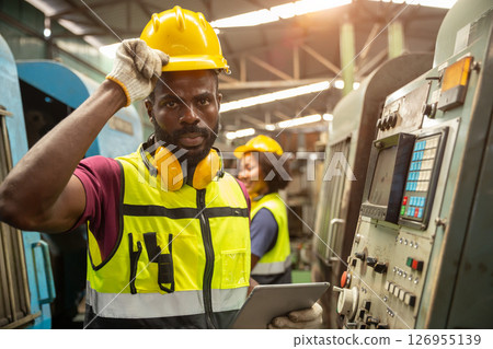 portrait African black professional technician engineer with heavy industry machine automated CNC in factory portrait African black professional technician engineer with heavy industry machine automated CNC in factory 126955139