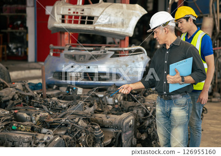 used car part business owner working check stock order with young technician man in second hand vehicle spare part center warehouse 126955160