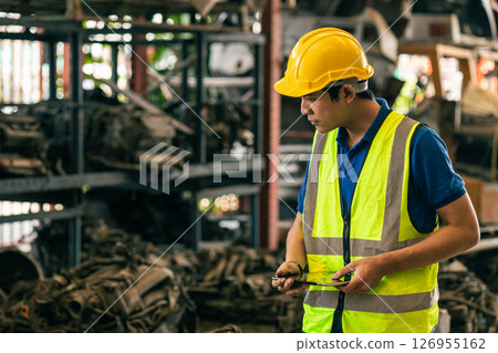 technician male worker working in scrapyard finding used car engine block order from customer at storage recycle area in warehouse technician male worker working in scrapyard finding used car engine block order from customer at storage recycle area in warehouse 126955162
