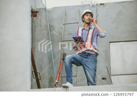 Asian engineer overseeing construction project at construction site, Professional builder working Asian engineer overseeing construction project at construction site, Professional builder working 126955797