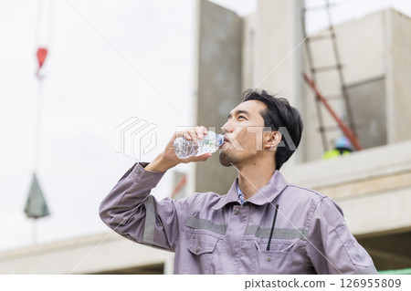 Asian worker male thirsty drinking water in hot summer weather working outdoor at construction site 126955809