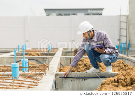 Asian construction engineer, Japanese builder worker male working inspecting footing house building. 126955817