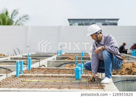 Asian construction engineer, Japanese builder worker male working inspecting footing house building. 126955820