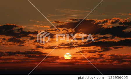 The setting sun glows warmly as golden hour clouds surround it 126956005