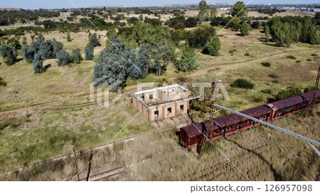 Abandoned Rail Stop and Derelict Carriage in Rural Landscape 126957098