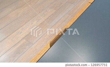 Cabinet of gray color with oak veneer facade and finger pull design on wooden floor background 126957731