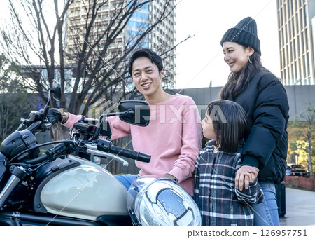 A man who got a long-awaited large motorcycle, his wife and children snuggling up 126957751