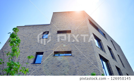 Eco architecture. Green tree and new residential building. Harmony of nature and modernity. Modern apartment building with new apartments in a green residential area. Eco architecture. Green tree and new residential building. Harmony of nature and modernity. Modern apartment building with new apartments in a green residential area. 126958145
