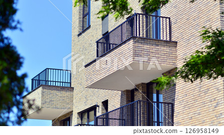 Eco architecture. Green tree and new residential building. Harmony of nature and modernity. Modern apartment building with new apartments in a green residential area. 126958149