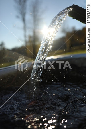 Stream of water is flowing out of a faucet Stream of water is flowing out of a faucet 126958236