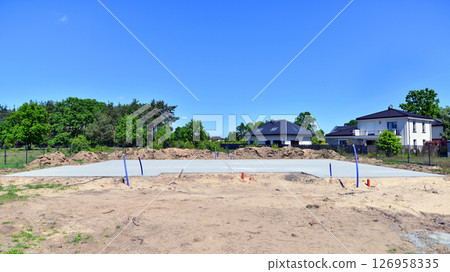 Concrete slab foundation for construction of a single-family house in a suburban residential development. 126958335