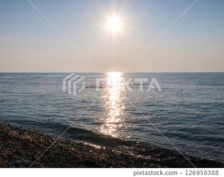 Sunlight stretching out over the sea: A tranquil seascape viewed from the shore 126958388