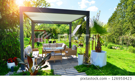 Modern aluminum pergola with stylish garden furniture in a beautiful garden. 126958423