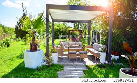 Modern aluminum pergola with stylish garden furniture in a beautiful garden. Modern aluminum pergola with stylish garden furniture in a beautiful garden. 126958431
