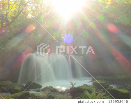 Oirase Gorge waterfall and rays of light shining through it - a soothing landscape in the sunlight filtering through the trees Oirase Gorge waterfall and rays of light shining through it - a soothing landscape in the sunlight filtering through the trees 126958646