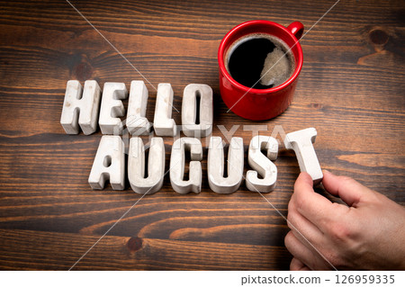 Hello August. Concrete alphabet letters and coffee mug on dark wooden texture background Hello August. Concrete alphabet letters and coffee mug on dark wooden texture background 126959335