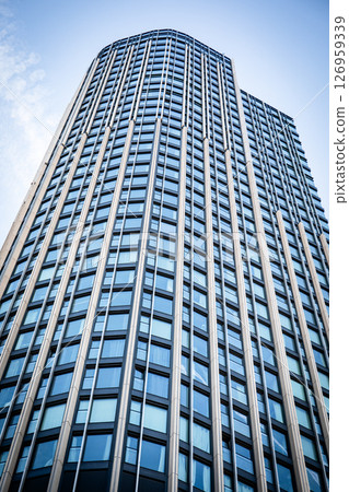 Modern Skyscraper Architecture with Glass Windows Reflecting Urban Sky Modern Skyscraper Architecture with Glass Windows Reflecting Urban Sky 126959339