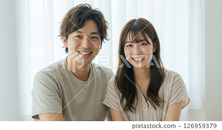一對年輕夫婦微笑著互相擁抱。朋友、夥伴、情人、婚姻、新婚夫婦的圖像。 126959379