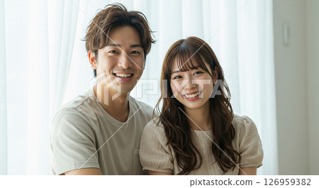 一對年輕夫婦微笑著互相擁抱。朋友、夥伴、情人、婚姻、新婚夫婦的圖像。 一對年輕夫婦微笑著互相擁抱。朋友、夥伴、情人、婚姻、新婚夫婦的圖像。 126959382