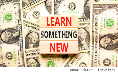 Learn something new symbol. Concept words Learn something new on beautiful wooden blocks. Beautiful background from dollar bills. Business motivational lifestyle learn something new concept Copy space 126961629