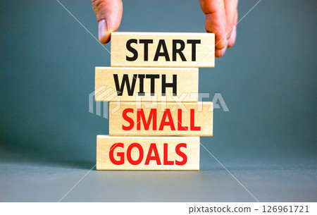Start with small goals symbol. Concept words phrase Start with small goals on beautiful wooden blocks. Beautiful grey background. Businessman's hand. Business Start with small goals concept Copy space 126961721