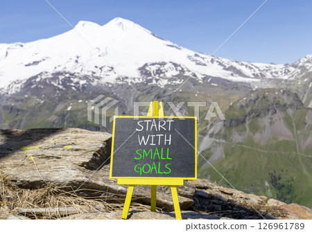 Start with small goals symbol. Concept words phrase Start with small goals on beautiful black blackboard. Beautiful mountain Elbrus background. Business Start with small goals concept. Copy space. 126961789