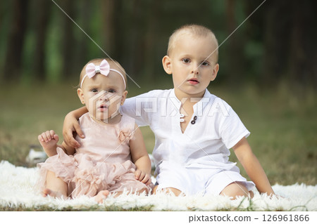 Portrait of an older brother and little sister for a walk in the park. Portrait of an older brother and little sister for a walk in the park. 126961866