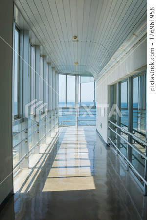 A bright corridor with a view of the ocean in the distance A bright corridor with a view of the ocean in the distance 126961958