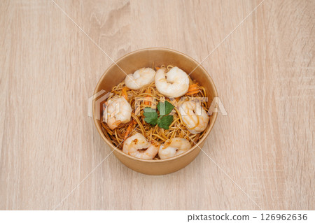 shrimp fried noodles in paper takeout container. Delicious freshly prepared meal, perfect for menus, restaurants, or food delivery concepts. shrimp fried noodles in paper takeout container. Delicious freshly prepared meal, perfect for menus, restaurants, or food delivery concepts. 126962636