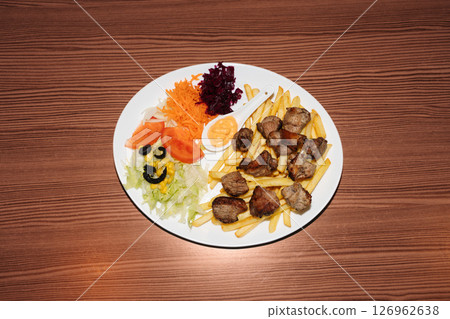 Turkish kebab plate with fries, vegetables and pork. Delicious freshly prepared meal, perfect for menus, restaurants, or food delivery concepts. Turkish kebab plate with fries, vegetables and pork. Delicious freshly prepared meal, perfect for menus, restaurants, or food delivery concepts. 126962638