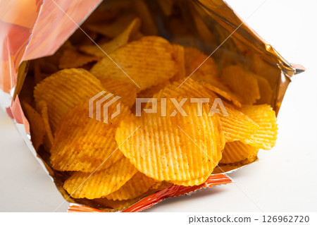 Potato chips, delicious BBQ seasoning spicy for crips, thin slice deep fried snack fast food in open bag. Potato chips, delicious BBQ seasoning spicy for crips, thin slice deep fried snack fast food in open bag. 126962720