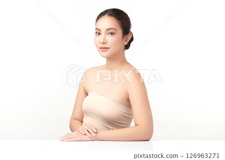 A beautiful young Asian woman with clean, fresh skin against a white background. Skincare, facial treatment, cosmetology, beauty, and spa. An elegant portrait of an Asian woman. 126963271