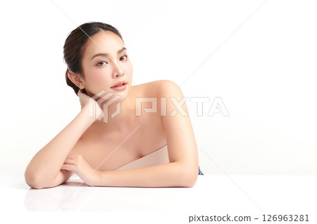A beautiful young Asian woman with clean, fresh skin against a white background. Skincare, facial treatment, cosmetology, beauty, and spa. An elegant portrait of an Asian woman. 126963281