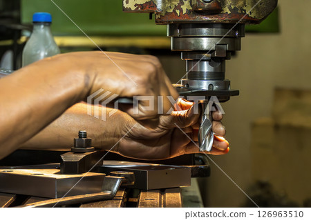 The skill operator working with NC milling machine. The skill operator working with NC milling machine. 126963510