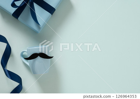 Happy Fathers Day. Creative greeting card with blue cup of coffee, tie and gift box on light blue background. Men's accessories set. Top view. Copy space. Happy Fathers Day. Creative greeting card with blue cup of coffee, tie and gift box on light blue background. Men's accessories set. Top view. Copy space. 126964353