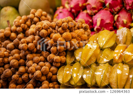 A pile of Asian fruits on the shelves, including bananas, mangoes and starfruit A pile of Asian fruits on the shelves, including bananas, mangoes and starfruit 126964363