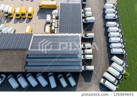 Delivery vans and trucks hub with solar panels on a roof. Fleet of vehicles. 126964691