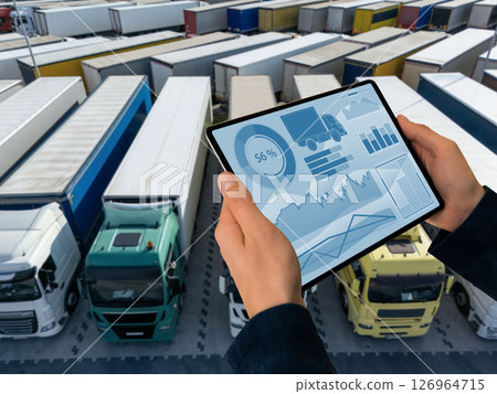 Manager with a digital tablet on the background of trucks. Fleet management. Manager with a digital tablet on the background of trucks. Fleet management. 126964715