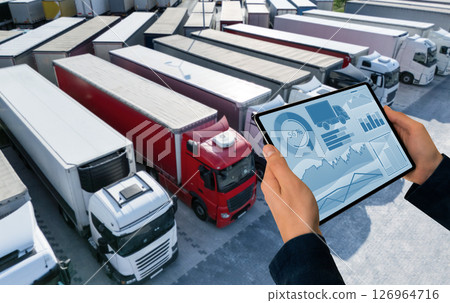 Manager with a digital tablet on the background of trucks. Fleet management. 126964716