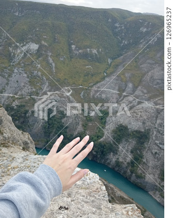 Woman stretching hand over Sulak Canyon's abyss, mesmerizing Aerial view, Dubki village, Dagestan, Russia Woman stretching hand over Sulak Canyon's abyss, mesmerizing Aerial view, Dubki village, Dagestan, Russia 126965237