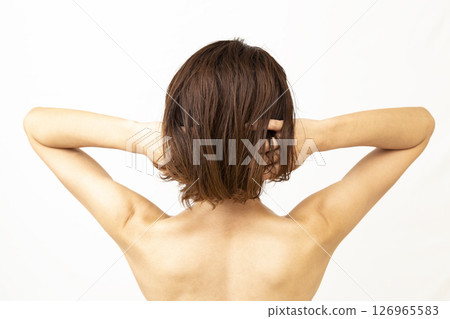 一位女士梳理著背上的頭髮 一位女士梳理著背上的頭髮 126965583